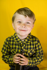 Baby with a hair spray and an incredible smile on a yellow background
