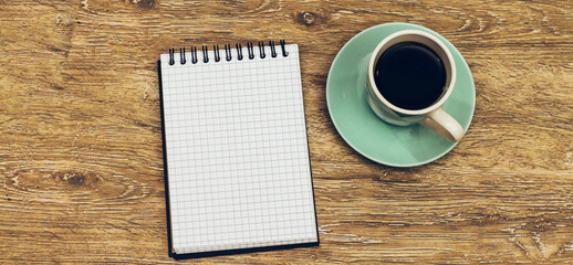 Obraz na płótnie Canvas A Blank White Notebook And Coffee On The Desk