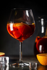 Refreshing red wine sangria or punch with fresh fruits in glasses and pincher on black background