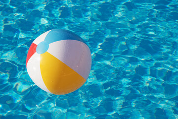 Colorful inflatable ball floating in swimming pool
