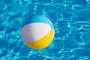 Colorful inflatable ball floating in swimming pool