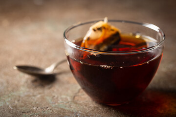 Tea bag in a transparent glass cup with hot water