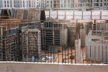 Large scale construction site featuring the foundation of what will be a large skyscraper.