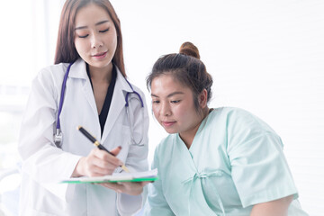Asian female doctor is describing the diagnosis of female patients regarding obesity. Medical and...