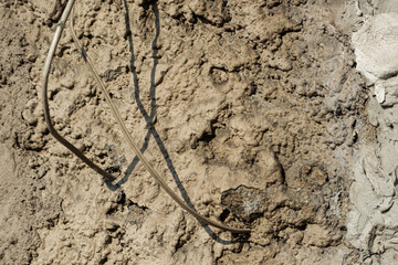 Wires on the background of a rough stone wall with putty, soft focus