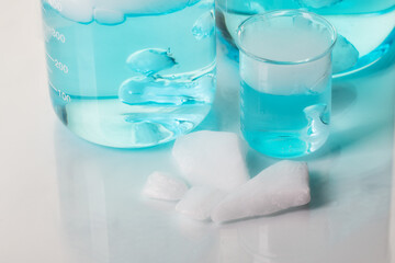 Beakers with blue liquid and white steam. Blocks of carbon dioxide. Experiment with dry ice. 
