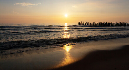 Beautiful sunset on the Baltic Sea, reflected in the sand and water