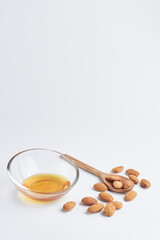 almonds with a wooden spoon and honey in a piala on a white background. healthy food. copy space for text