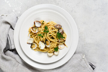 food delivery from restaurants pasta with clams and parsley Spaghetti alle Vongole in white plates on a grey background. recipe food seafood.  top view