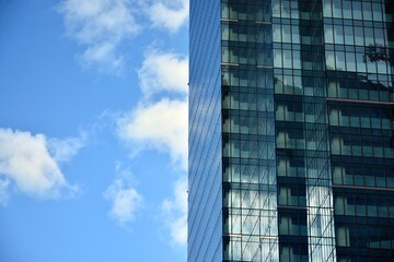 Fototapeta premium Facade texture of a glass mirrored office building. Fragment of the facade. Modern architecture of the office building.