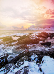 Beach of Norwegian sea on rocky coast in fjord on sunset in winter. Vareid beach, Lofoten islands, Norway. Norway amazing nature.