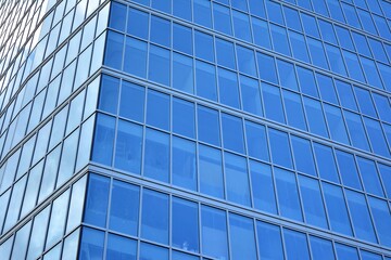 Obraz premium Facade texture of a glass mirrored office building. Fragment of the facade. Modern architecture of the office building.