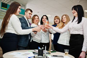 Portrait of young business people group of bank workers in modern office drinking champagne after hard work day.