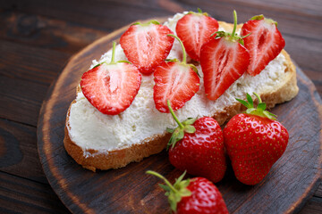 Strawberry bruschetta with cottage cheese. Homemade healthy toast, delicious snack for kids. Fruit sweet sandwich with ripe summer berries