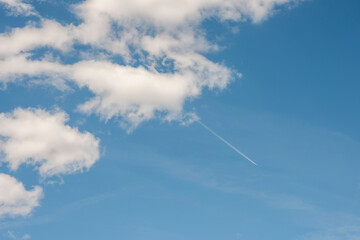Naklejka na ściany i meble white clouds in the sky airplanes condensation streak 