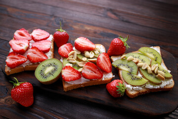 Healthy dessert, sweet fruit toasts with kiwi, strawberry and ricotta. Delicious homemade low...
