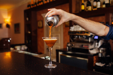 the waiter pours a cocktail close up