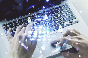 Social network concept with world map and hands typing on laptop on background. Multiexposure