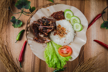 Burung dara goreng or fried pigeons are a traditional Indonesian meal mixed with spicy sauce and rice.