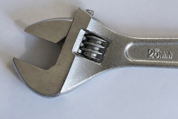 chrome adjustable spanner on light gray background. Diameter 25mm. Worker’s tools. Mechanism.