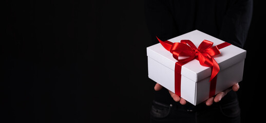 close-up Man holding a gift box on a black background