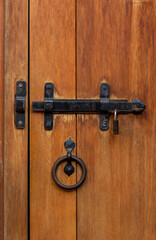 Old iron lock and bolt on the wooden door close-up