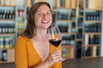 young woman brunette drinking a glass of red wine in a winebar
