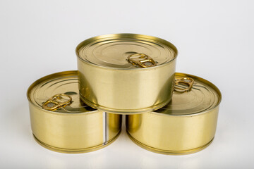 A metal tin cans on a white table. Food with a long shelf life.