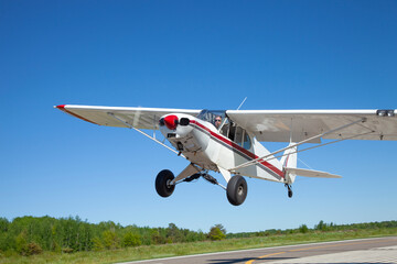 Small single engine airplane takes off from a municipal airfield in rural Minnesota
