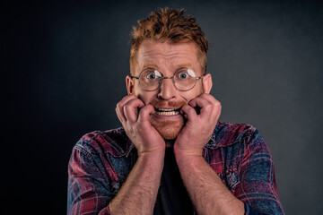 Guy freaking out, feeling worried and scared someone know his secret, biting fingernails and frowning staring intense at camera, having terrible thoughts in mind, overreacting and panicking