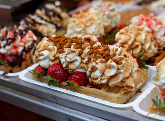 Brussel Waffles, a delicious dessert with strawberry, whipped cream and 
speculoos biscuit crumbs