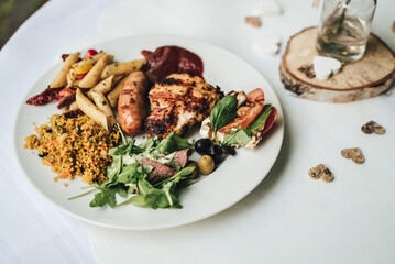 White plate with food got from self-service buffet table. Love hearts table decoration. Celebration, party, birthday or wedding concept.