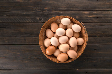 chicken eggs in a basket on a wooden background