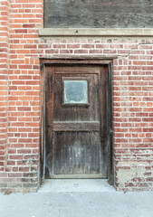 Fototapeta na wymiar Rotted wood vintage door of an abandoned brick factory building.