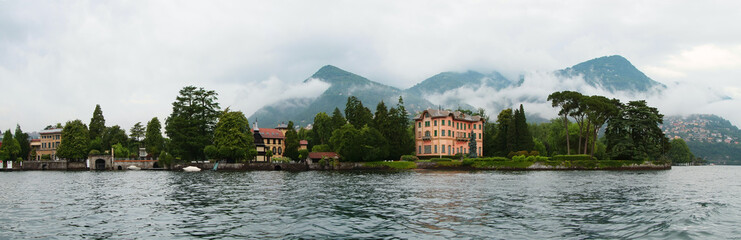Fototapeta na wymiar Panoramic view of Como lake with villages and mountains shrouded in clouds. Tavernola. Italy.