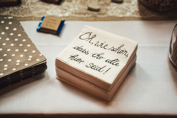Stack of paper napkins laying on serving table. Translation: 