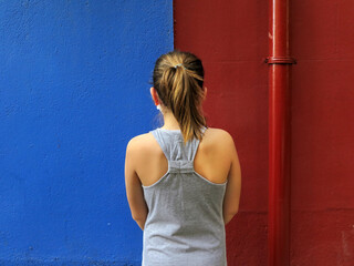 girl with her back to a colorful wall