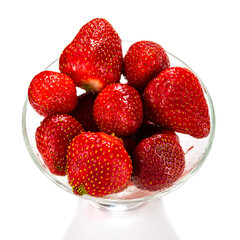 A lot of fresh strawberries in a glass vase isolated on a white background close-up