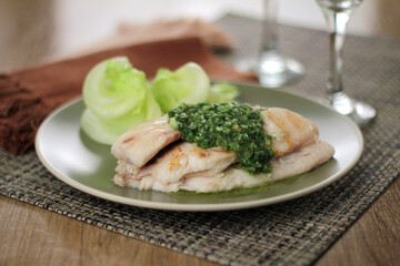 Fish fillet with pesto sauce and lettuce salad