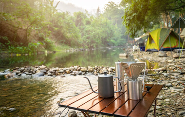 coffee drip while camping near the river in nature park - obrazy, fototapety, plakaty