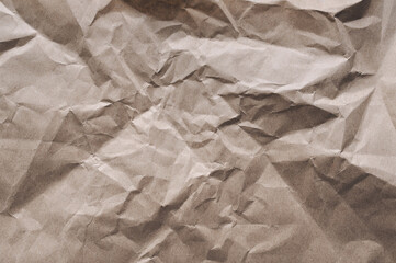 Background from old crumpled light brown wrapping vintage paper. The texture of cardboard made from recycled materials top view.