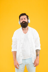 Audio enjoyment. Perfect sound. Hipster listen music stereo headphones. Modern wireless headphones. Electronic music and house tracks. Instrumental music. Bearded man headphones yellow background