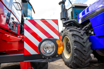 new clean right headlight with a reflector on the bumper of a red tractor