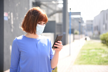 Girl in the surgical mask with smartphone