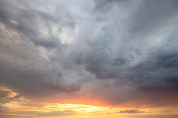 Sunset sky covered with orange puffy clouds in the evening.