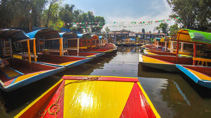 Traditional Mexican trajinera boat in the Xochimilco channels in Mexico City. Lake full of colorful...