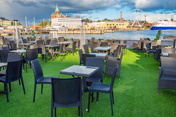 Naklejka premium Helsinki. Cruise port of the capital of Finland. Street cafe on the waterfront. Panorama of the Helsinki waterfront. Cruise ship, Ferris wheel and assumption Cathedral. Sightseeing tour of the city.