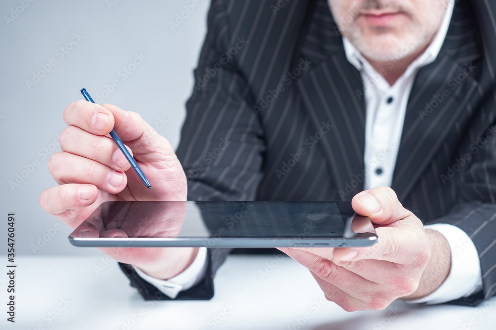 Poster a man looks at information on a tablet. tablet with a stylus. ordering a product from an online stor