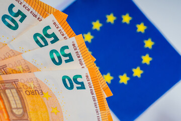 Euro against the background of the EU flag. single European currency. Dynamics of the Euro exchange rate. Financial policy of the EU countries. Work in the European Community.