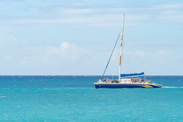 Obraz premium Philipsburg, Sint Maarten. Group of people have fun day sailing the ocean in yacht/ catamaran. Tourists on vacation on tropical Caribbean island coast.